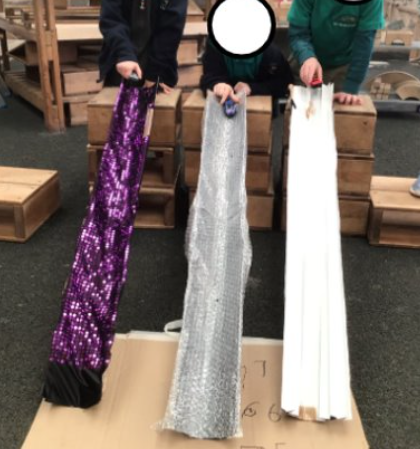 Three ramps made from drainpipe. One is lined with sequinned fabric and another with bubblewrap.