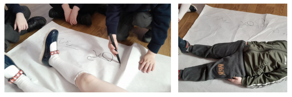 A child having their height measured by lying on a sheet of paper with a number scale.