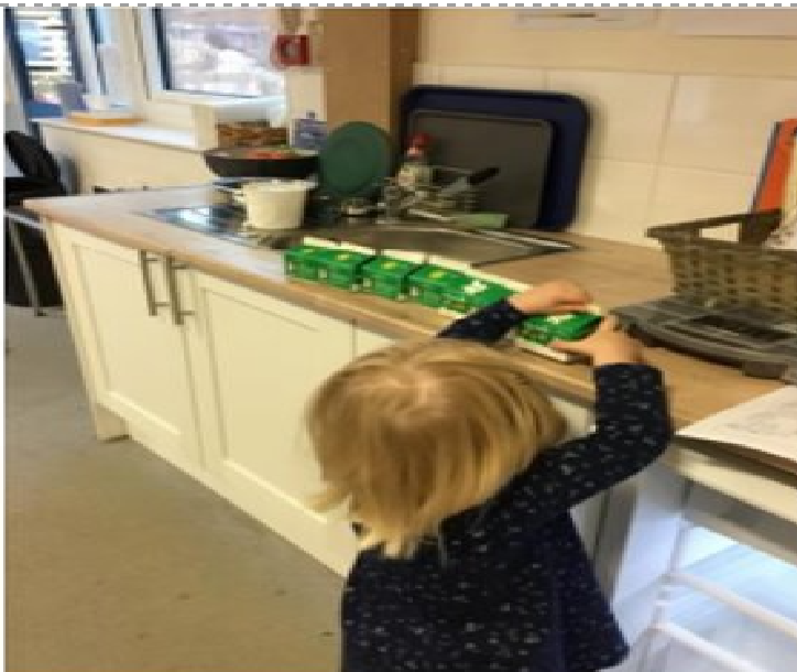 A child lining up cartons of milk