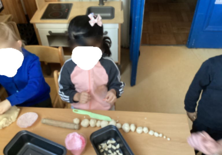 A child making different sized balls from playdough and arranging them in size order