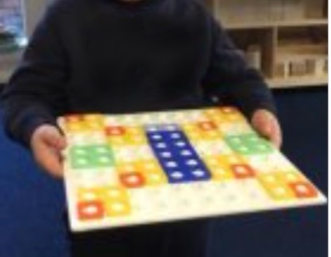 A child showing a pattern they had made from Numicon pieces