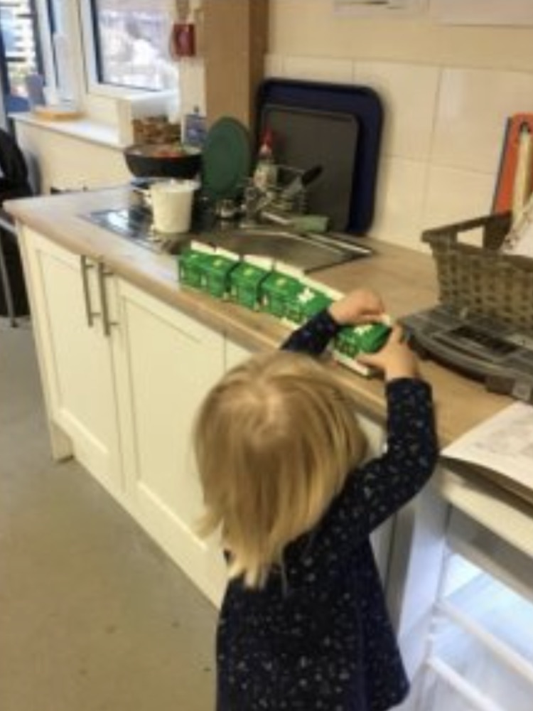 A child lining up cartons of milk