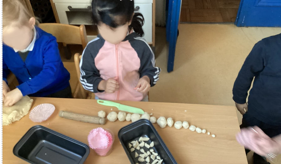 A child making different sized balls from playdough