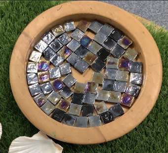 Square tiles inside a circular frame with small gaps between them.