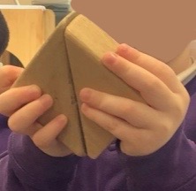 A child putting two triangles together to get a square